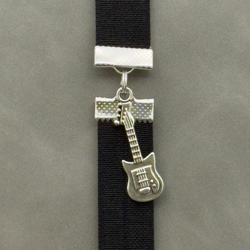 A silver electric guitar charm on an elastic Bookband
