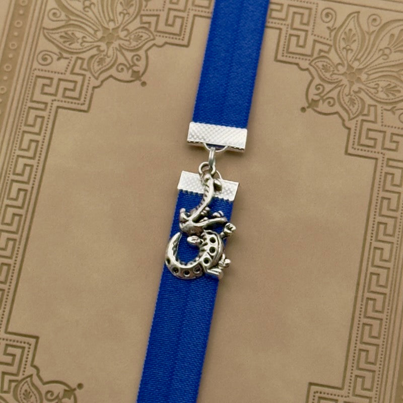 A silver cheerful crocodile charm on an elastic Bookband