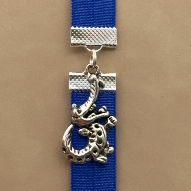 A silver cheerful crocodile charm on an elastic Bookband