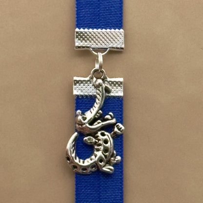 A silver cheerful crocodile charm on an elastic Bookband