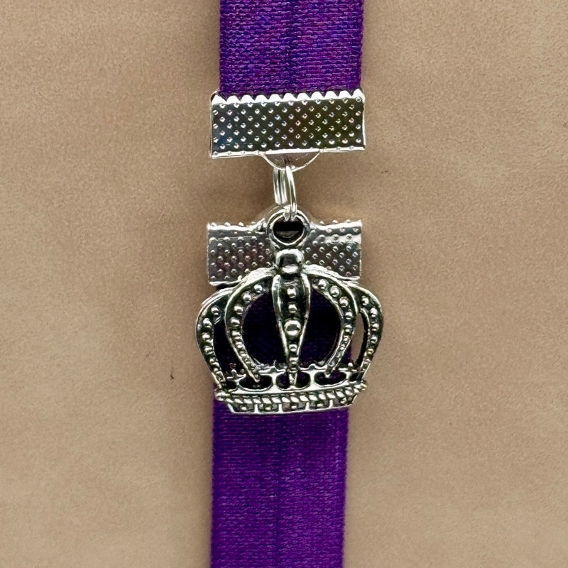 A silver royal crown charm on an elastic Bookband