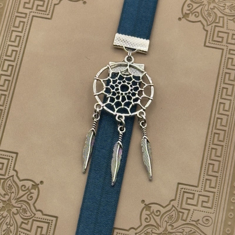 A silver dreamcatcher charm on a elastic Bookband