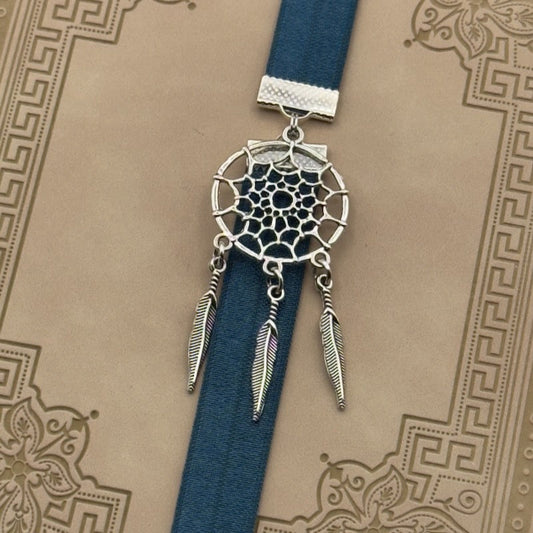A silver dreamcatcher charm on a elastic Bookband