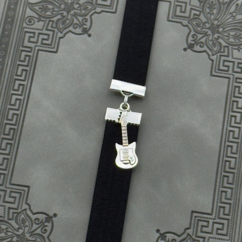 A silver electric guitar charm on an elastic Bookband