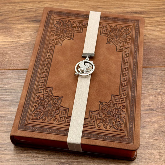 A silver Hunger Games Mockingjay charm on an elastic Bookband