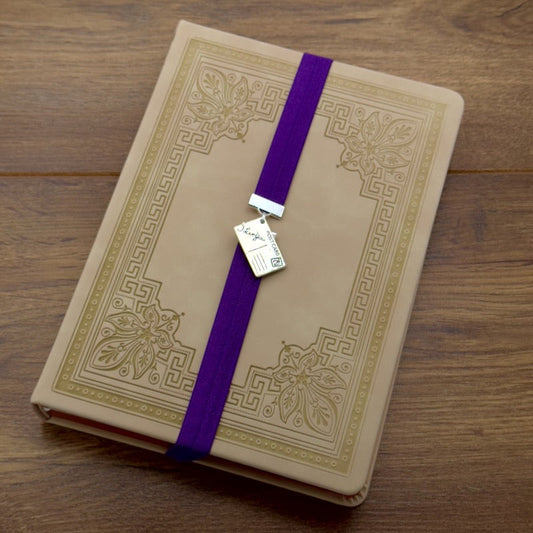 A silver postcard charm on an elastic Bookband