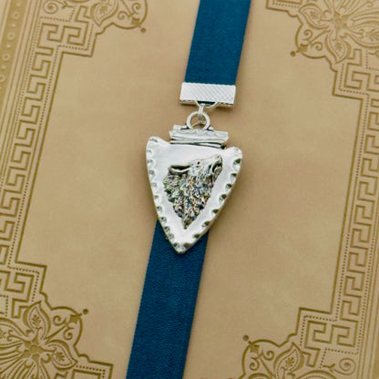 A silver arrowhead, with a howling wolf in the centre, charm on a elastic Bookband